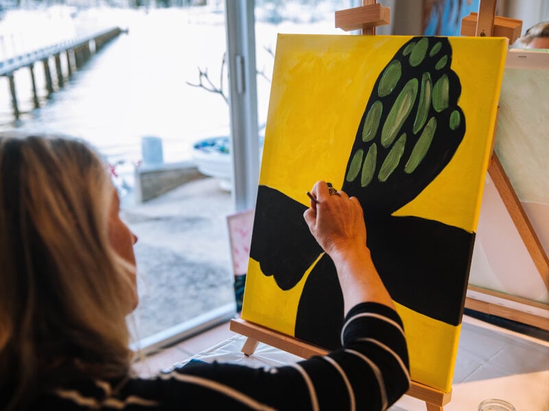 Woman painting a butterfly at a mobile paint and sip class